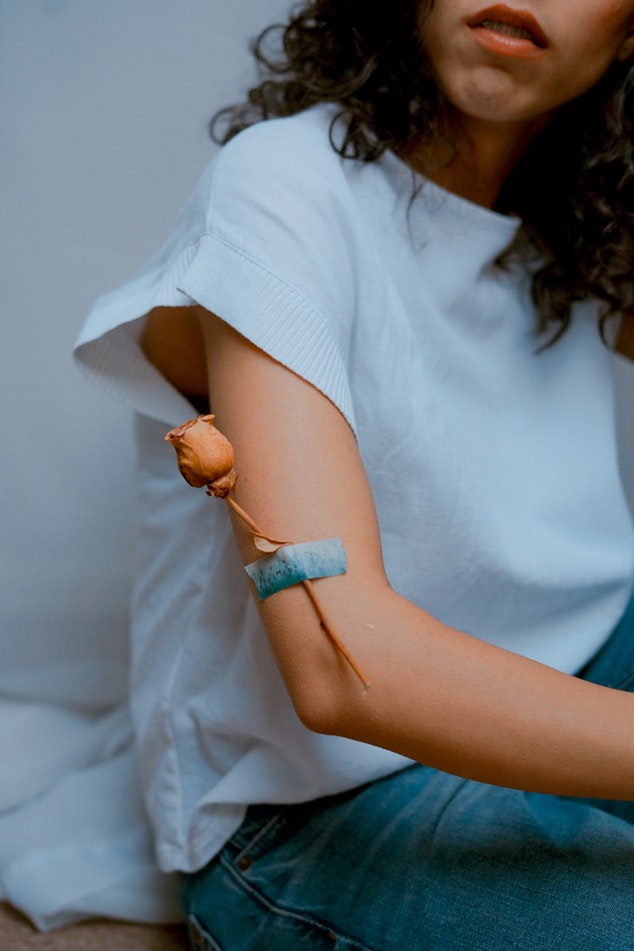 Jeune femme avec une rose accrochée sur le bras